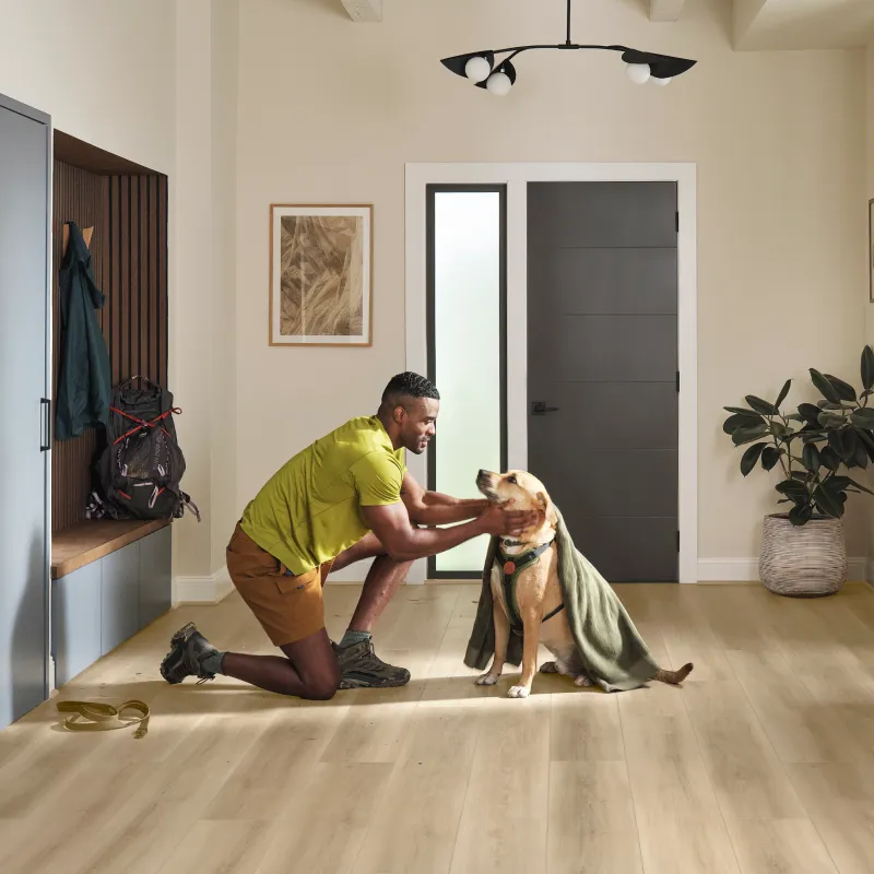 Man petting dog in modern entry way with water resistant flooring