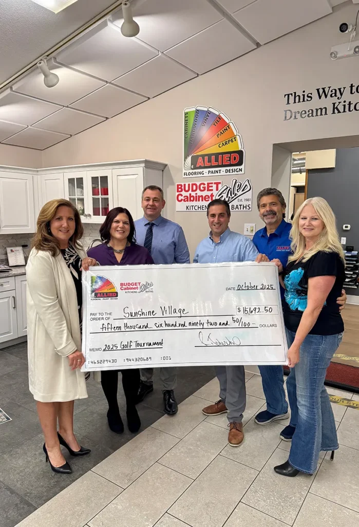 Allied Flooring and Budget Cabinets team presenting a $15,692.50 check from the 2025 Golf Tournament to Sunshine Village