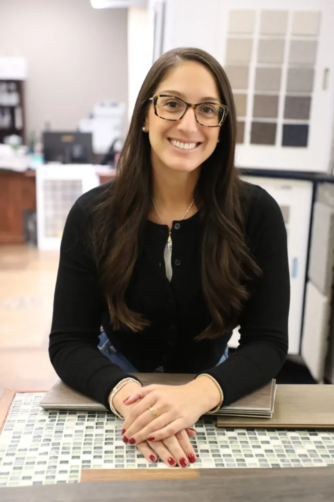 Allied Flooring team member smiling at a mosaic tile counter in the showroom